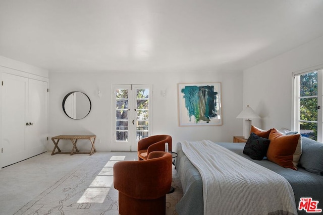 bedroom featuring access to exterior, french doors, and light colored carpet