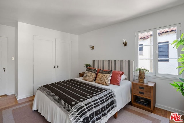 bedroom with a closet and hardwood / wood-style floors