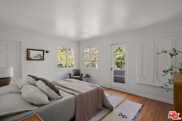 bedroom featuring hardwood / wood-style flooring and access to exterior