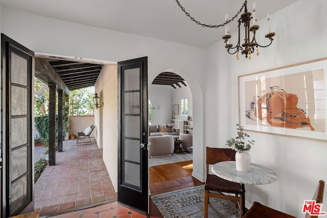 entryway with french doors, tile patterned flooring, and an inviting chandelier