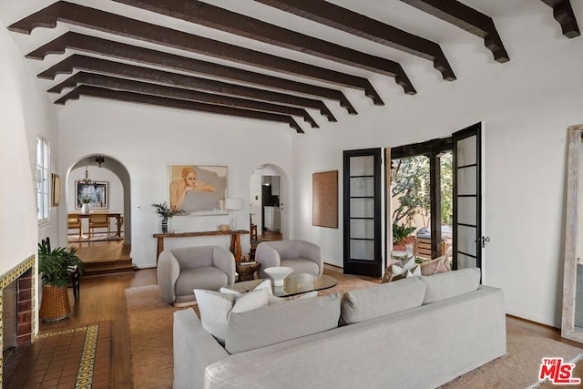 living room featuring beamed ceiling and wood-type flooring