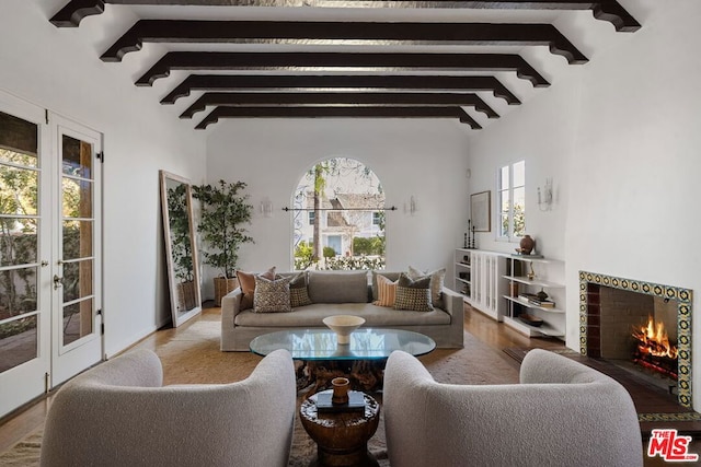 living room with french doors, lofted ceiling with beams, and light hardwood / wood-style flooring