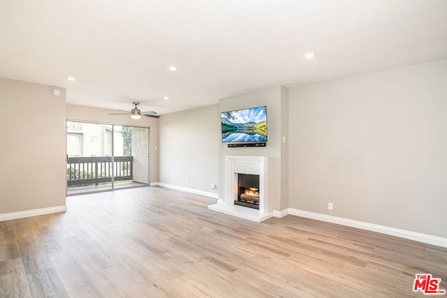 unfurnished living room featuring ceiling fan and light wood-type flooring