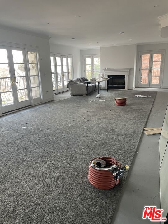 unfurnished living room featuring carpet floors and french doors