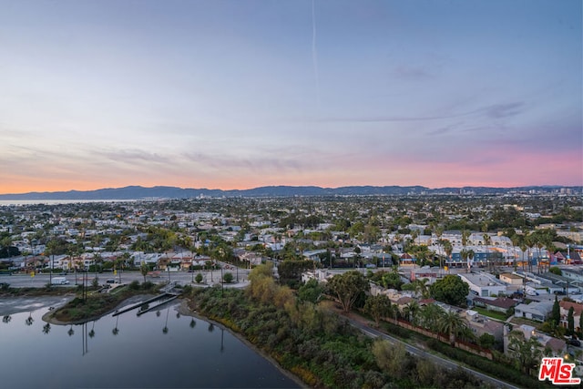 aerial view at dusk featuring a water view