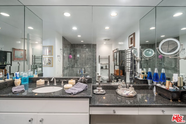 bathroom featuring vanity, toilet, and walk in shower