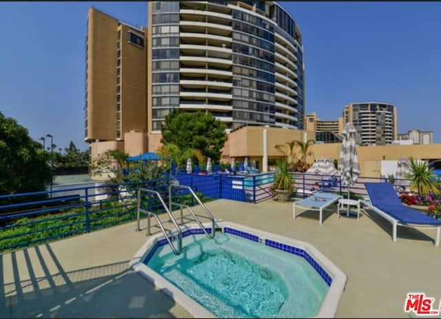 view of swimming pool with a patio and a hot tub