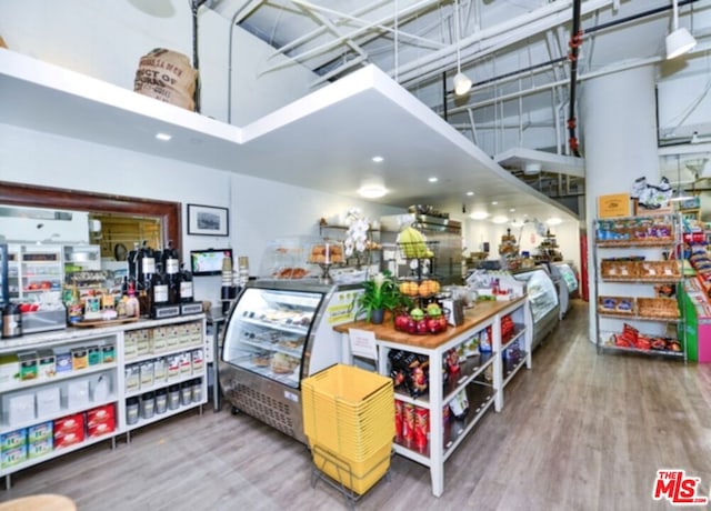 miscellaneous room with hardwood / wood-style floors and a towering ceiling