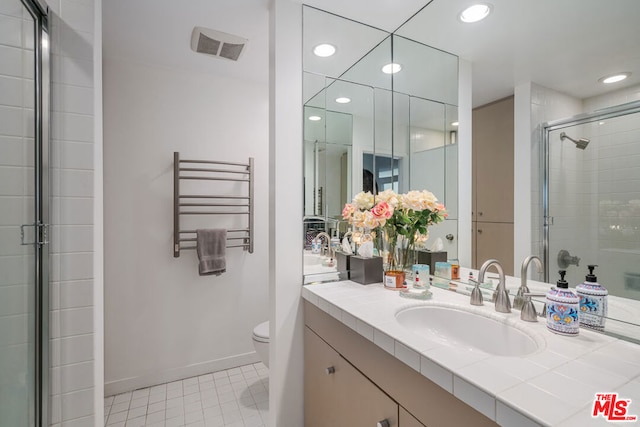 bathroom with radiator, tile patterned floors, an enclosed shower, toilet, and vanity