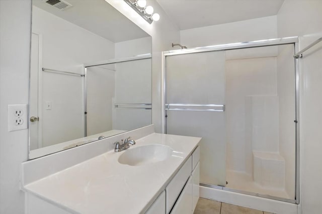 bathroom featuring tile patterned floors, walk in shower, and vanity