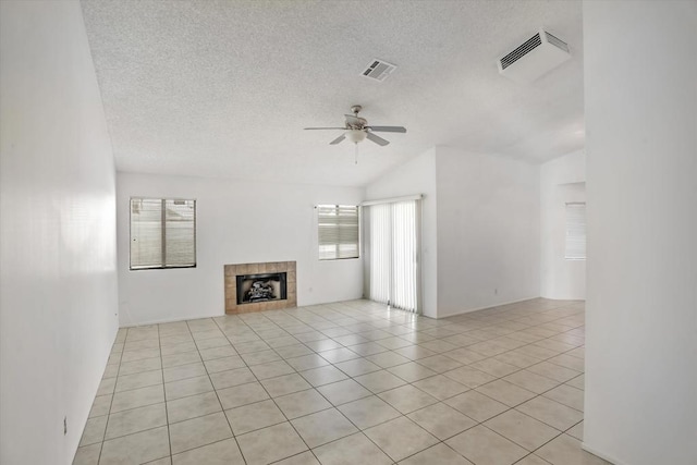 unfurnished living room featuring a textured ceiling, a fireplace, lofted ceiling, ceiling fan, and light tile patterned floors