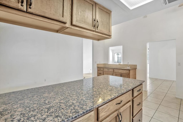 kitchen with dark stone counters and light tile patterned flooring