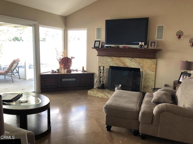 living room with a premium fireplace, plenty of natural light, and vaulted ceiling