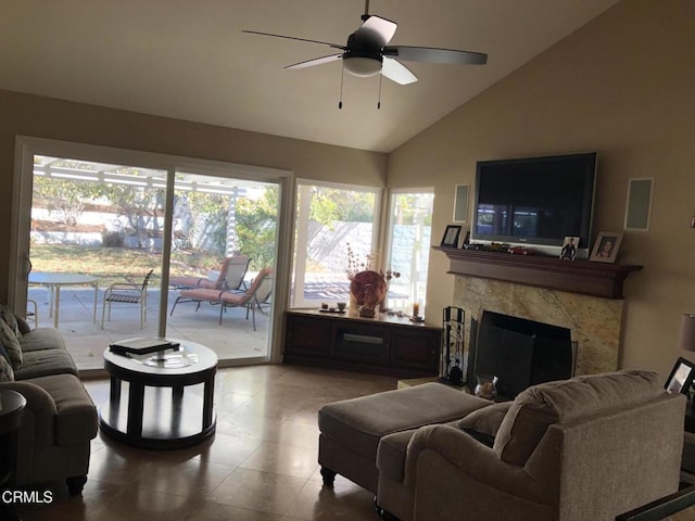 living room with ceiling fan, a fireplace, and vaulted ceiling