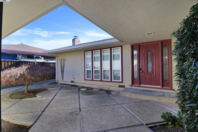 view of exterior entry featuring a patio