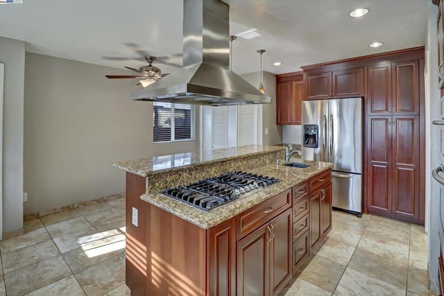 kitchen with hanging light fixtures, appliances with stainless steel finishes, island exhaust hood, light stone counters, and a kitchen island