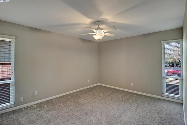 spare room featuring ceiling fan and carpet