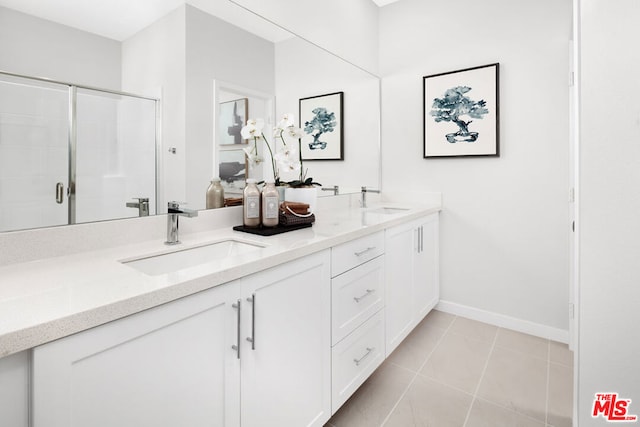 bathroom featuring tile patterned flooring, vanity, and a shower with door