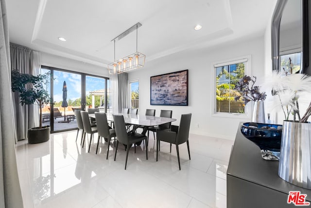 tiled dining space featuring a raised ceiling