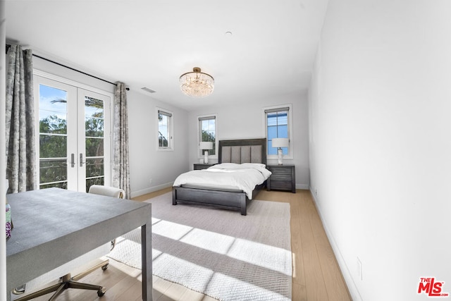 bedroom with access to outside, french doors, and light hardwood / wood-style floors