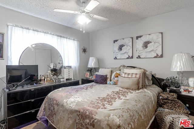 bedroom with ceiling fan and a textured ceiling