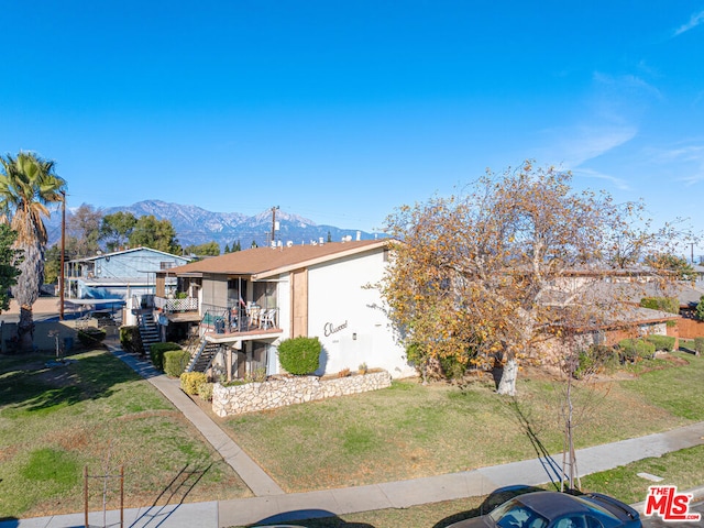 view of front of property with a mountain view and a front yard