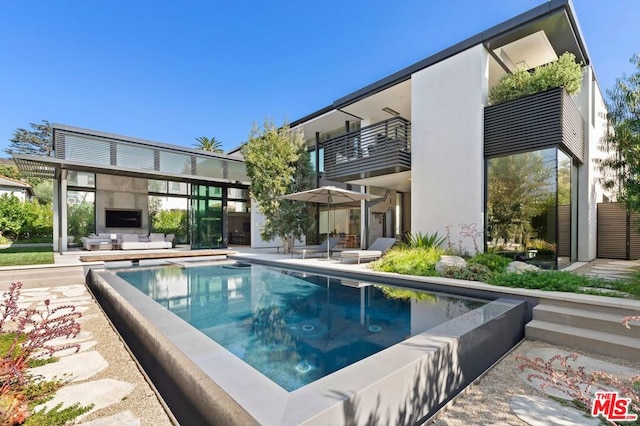 view of pool featuring a fireplace and a patio area