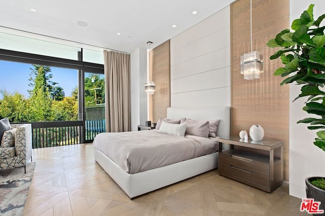 bedroom with access to exterior, wood walls, and light parquet floors