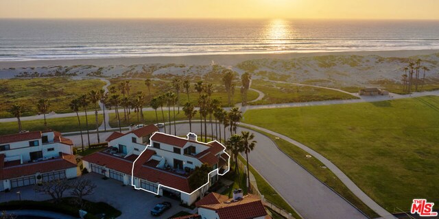 aerial view at dusk featuring a water view