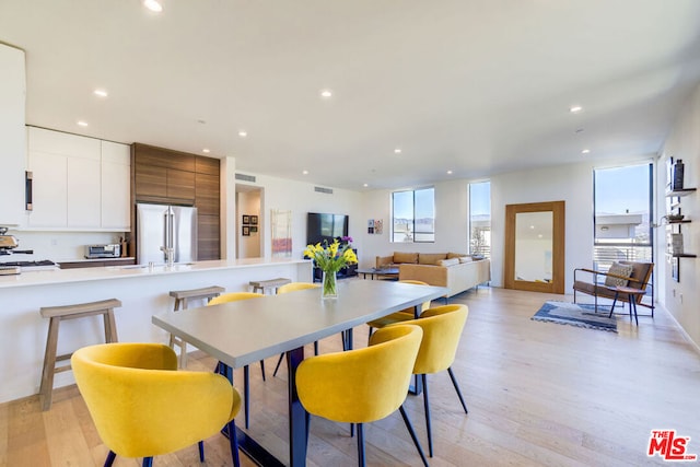 dining area with light wood-type flooring and sink