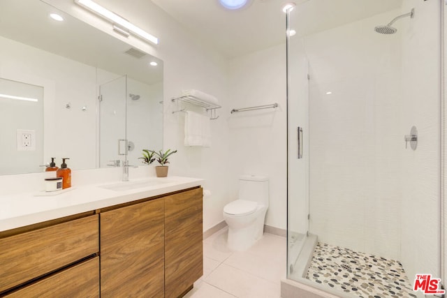 bathroom featuring walk in shower, tile patterned flooring, vanity, and toilet