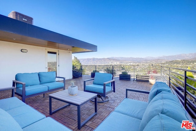 view of patio with outdoor lounge area, a mountain view, cooling unit, and a balcony