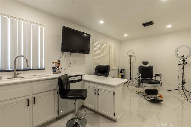 interior space featuring recessed lighting, a peninsula, a sink, visible vents, and light countertops