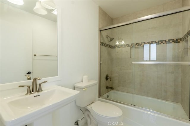 full bathroom with toilet, enclosed tub / shower combo, and a sink