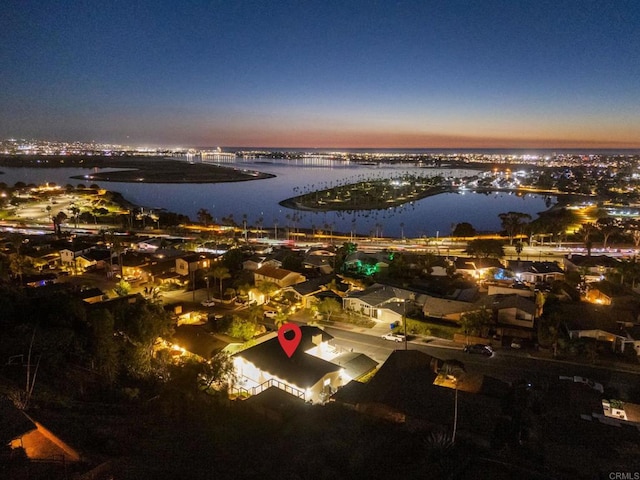 aerial view at dusk featuring a water view