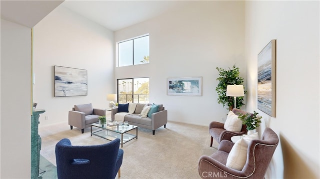 living room with light carpet and a towering ceiling