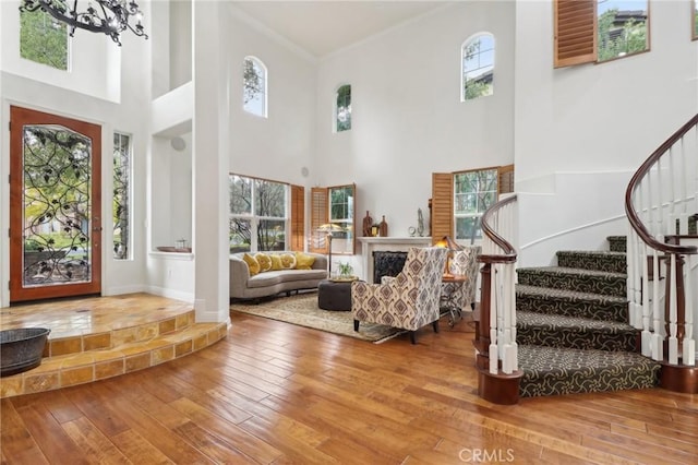 foyer entrance featuring ornamental molding, hardwood / wood-style floors, and an inviting chandelier