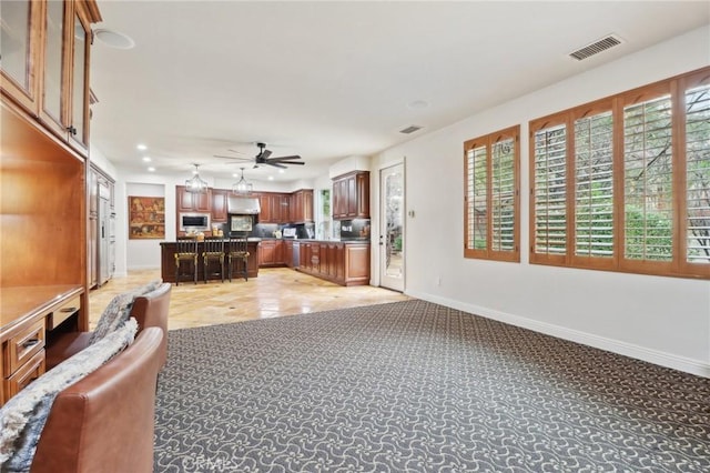 unfurnished living room featuring light colored carpet and ceiling fan