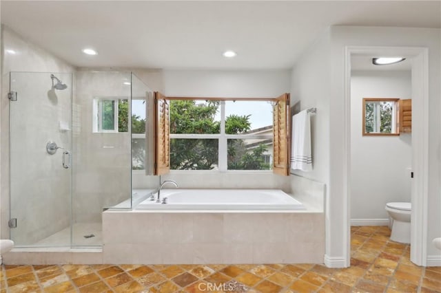 bathroom featuring plenty of natural light, toilet, and separate shower and tub