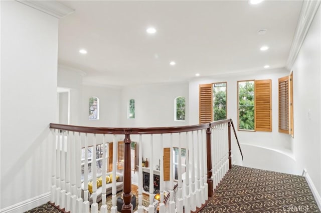 hallway with ornamental molding and carpet floors