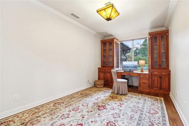 unfurnished office featuring hardwood / wood-style floors and ornamental molding