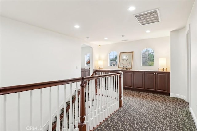 hall featuring sink and dark carpet