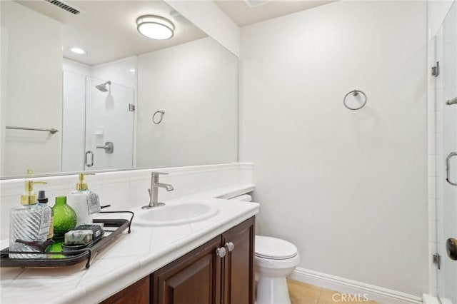 bathroom featuring vanity, tile patterned flooring, a shower with door, and toilet