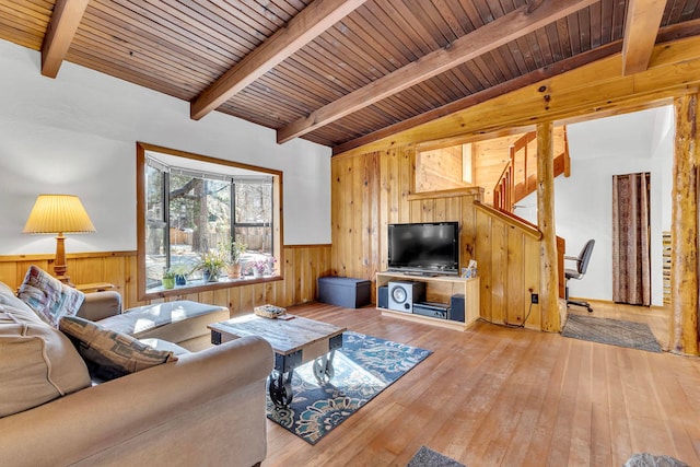 living room with lofted ceiling with beams, light hardwood / wood-style flooring, and wood ceiling