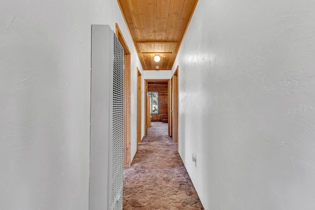 corridor with light carpet and wood ceiling