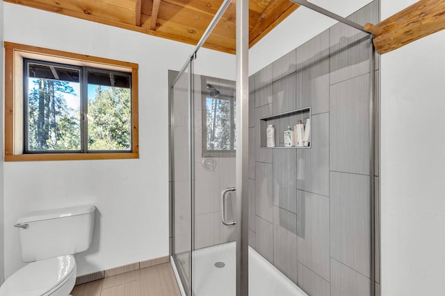 bathroom featuring toilet and a shower with shower door