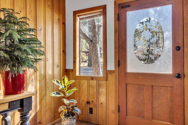 entryway with wood walls