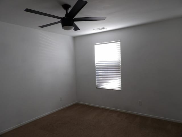 empty room featuring dark colored carpet and ceiling fan