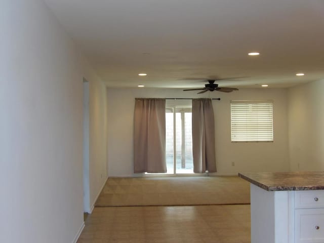 interior space with ceiling fan and white cabinets