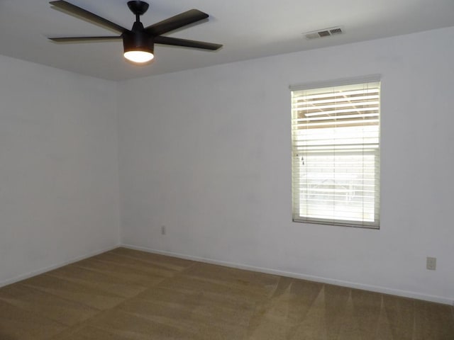 spare room featuring ceiling fan, carpet floors, and a wealth of natural light